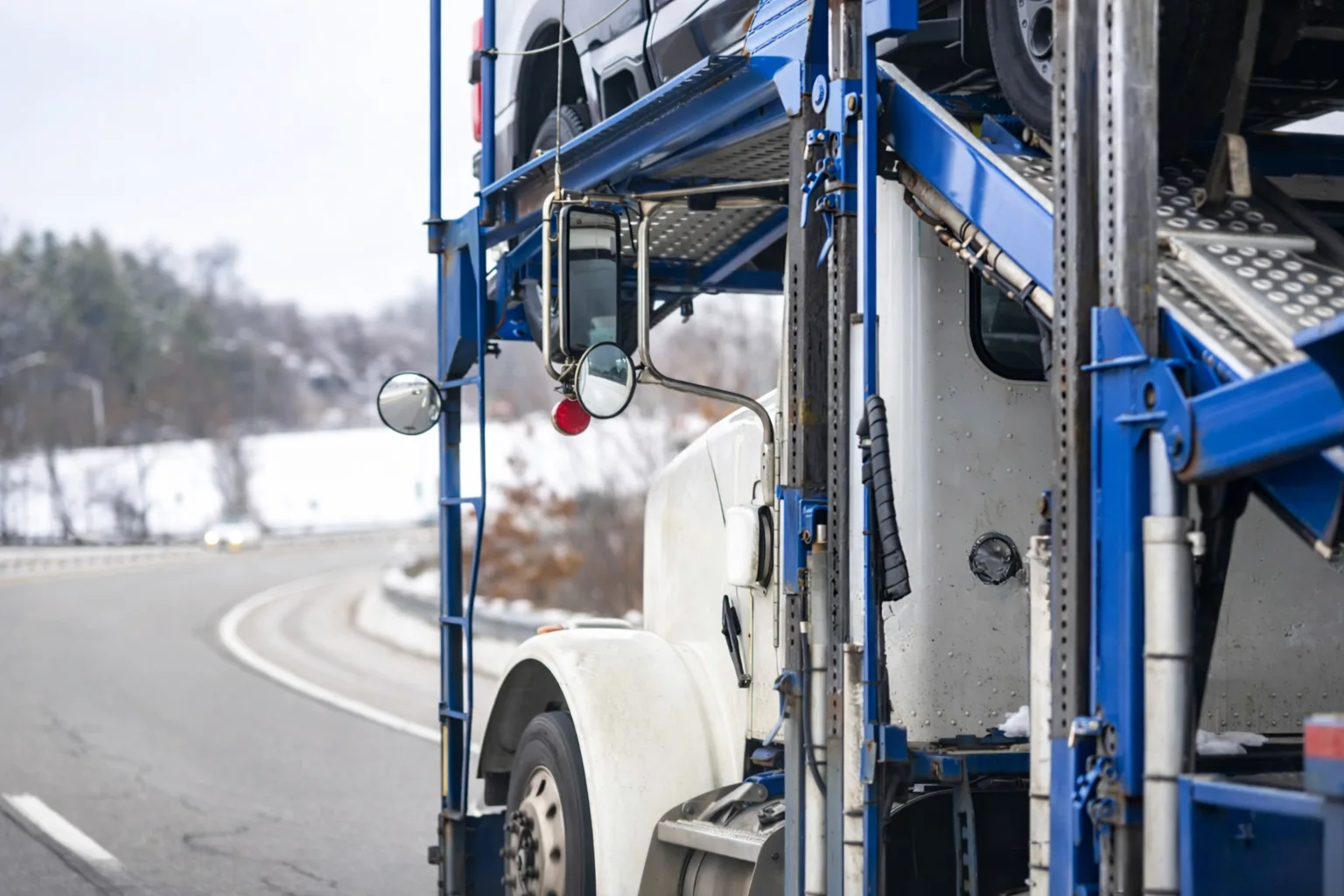 Car Transport Truck Driving Along a Snowy Road