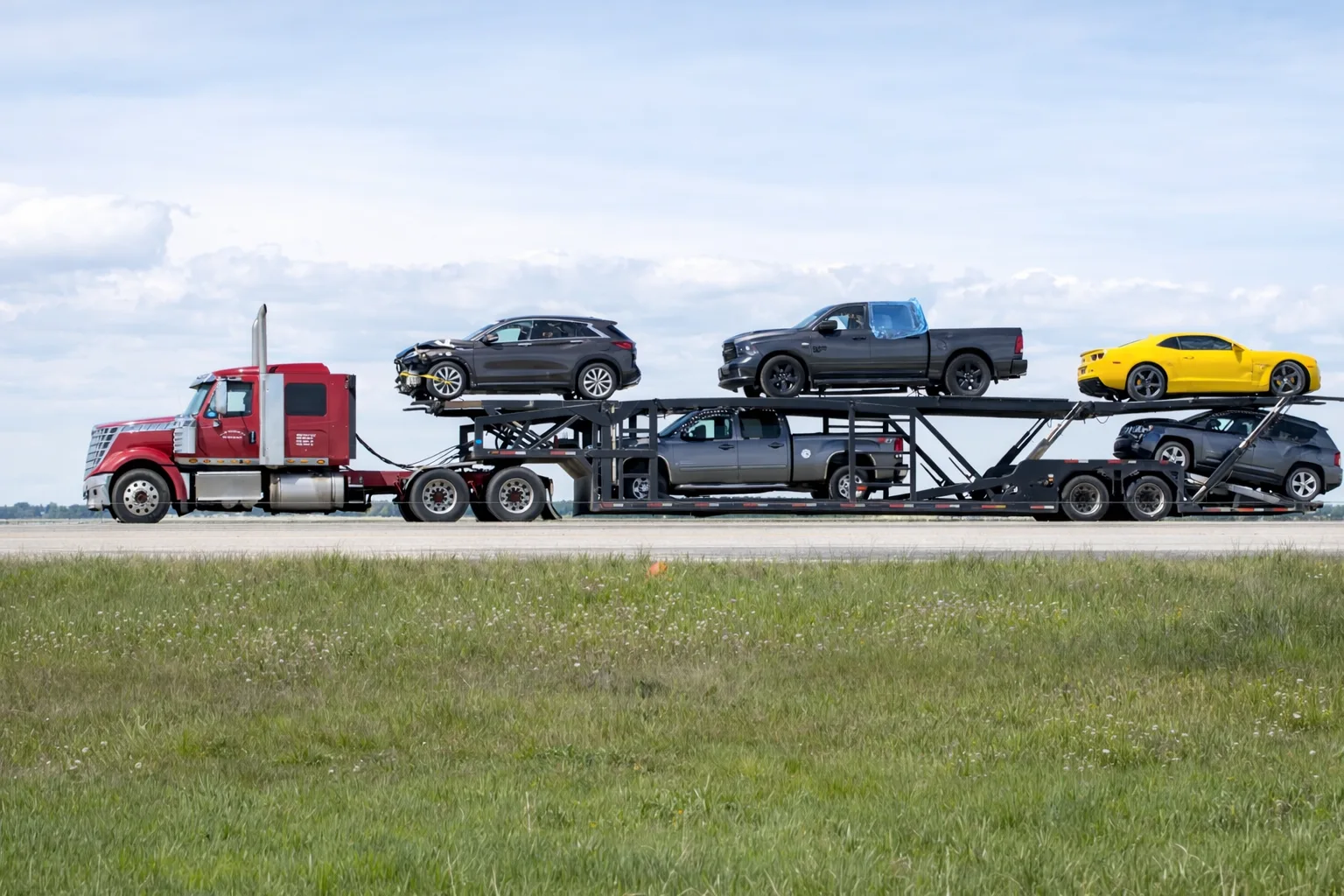 Side View of a Red Truck Delivering Cars